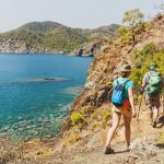 Group of Hikers walking by Lycian Way trail along wild beach and mountains in Turkey
